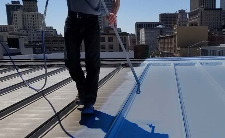 Contractor spraying FiberSeal Base